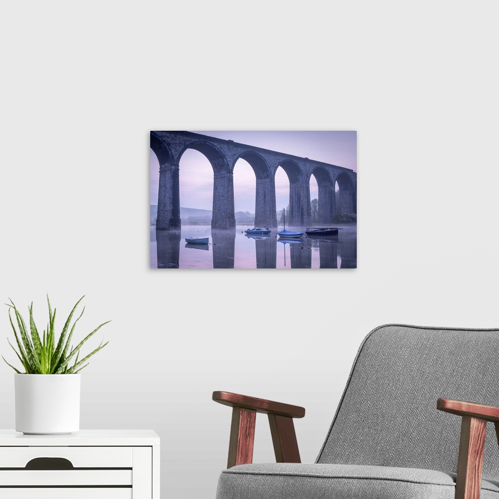A modern room featuring Boats beneath St Germans Victorian viaduct at dawn, St Germans in Cornwall, England.  Spring (Apr...