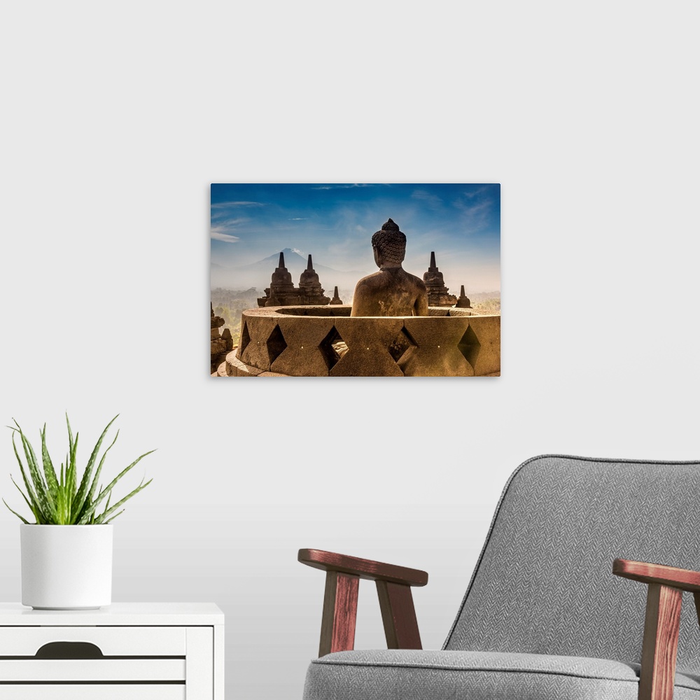 A modern room featuring Buddha statue with Mount Merapi in the background, Candi Borobudur Buddhist temple, Muntilan, Jav...