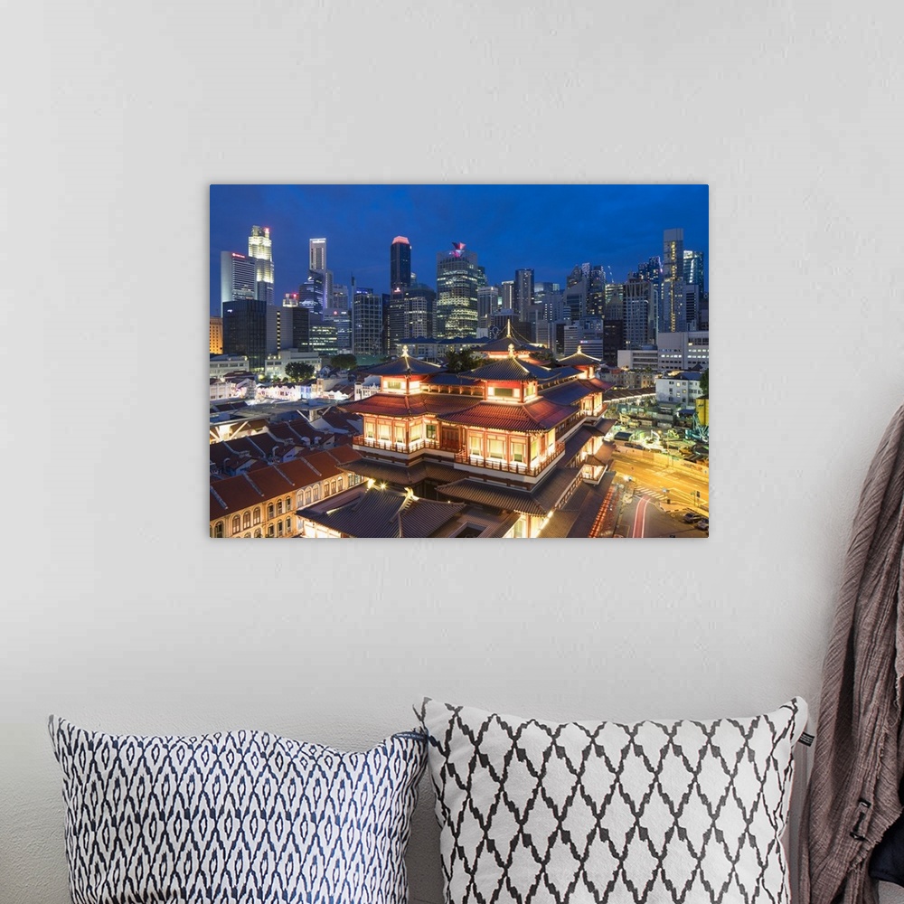 A bohemian room featuring Buddha Tooth Relic Temple and skyscrapers at dusk, Chinatown, Singapore.