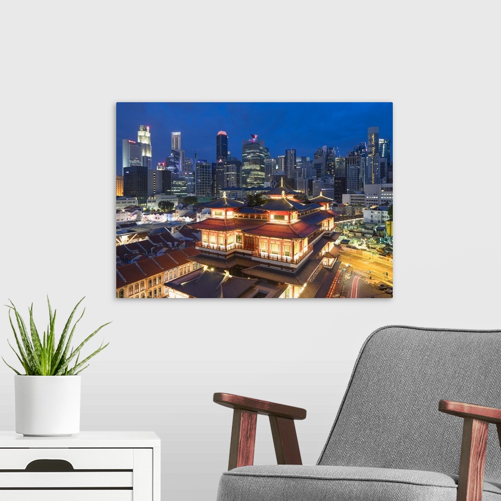 A modern room featuring Buddha Tooth Relic Temple and skyscrapers at dusk, Chinatown, Singapore.