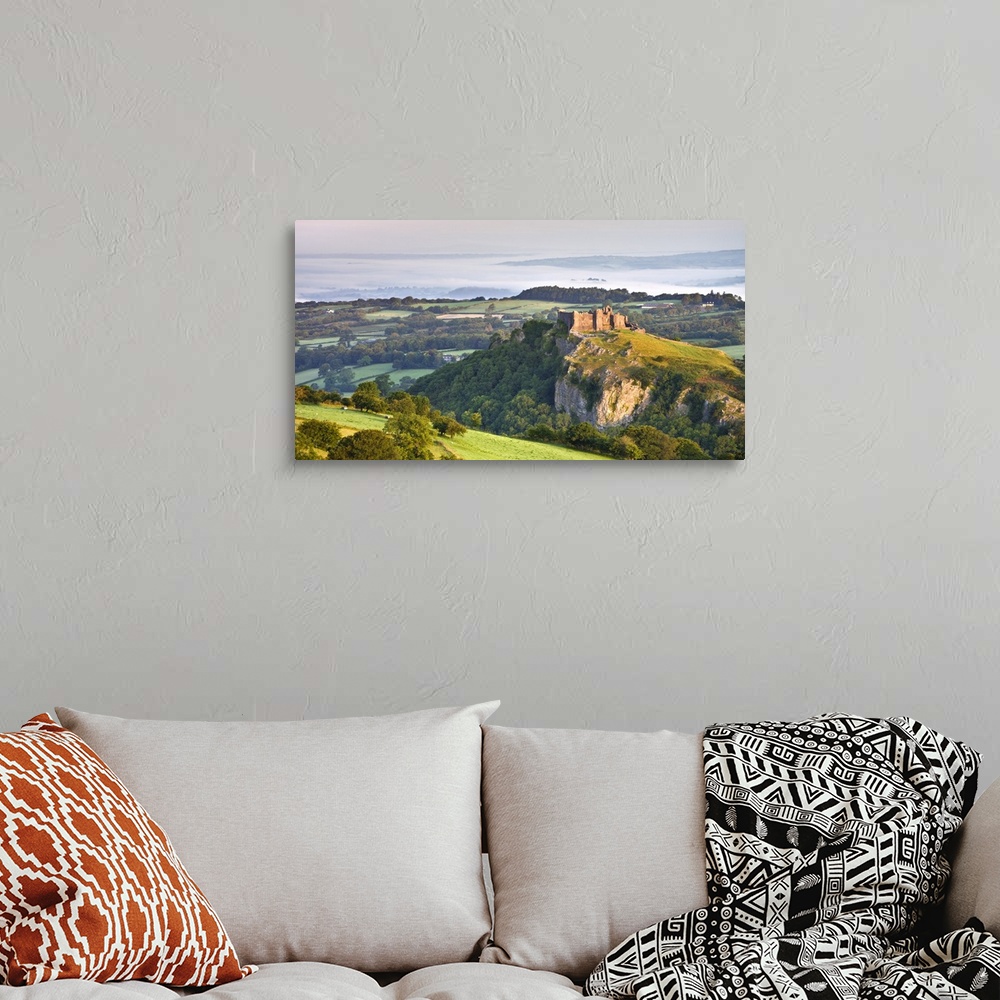 A bohemian room featuring Carreg Cennen Castle at dawn on a misty summer morning, Brecon Beacons National Park, Carmarthens...