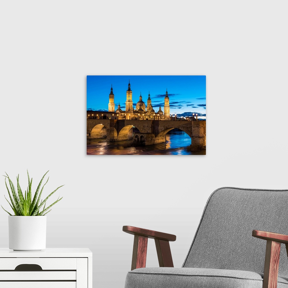 A modern room featuring Cathedral Of Our Lady Of The Pillar And Stone Bridge At Dusk. Zaragoza, Aragon, Spain