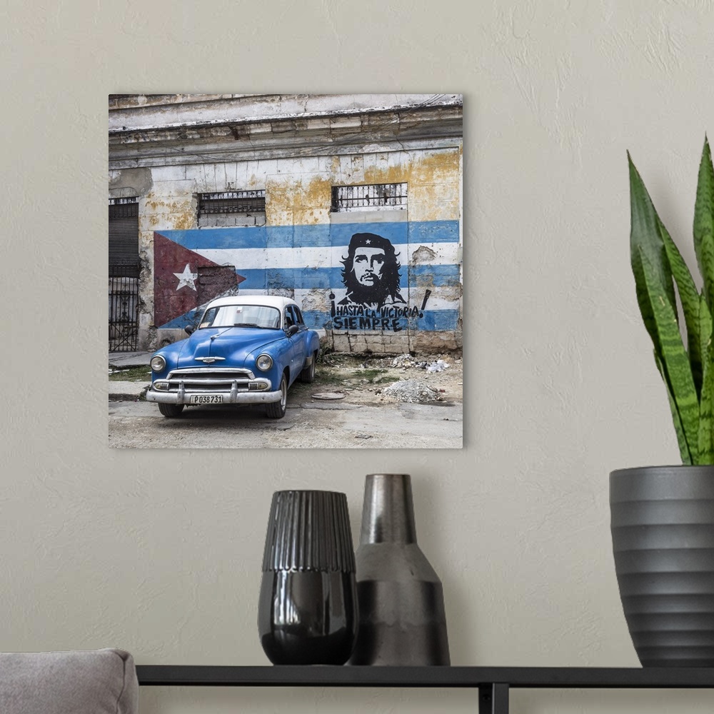 A modern room featuring Classic American car and Cuban flag, Habana Vieja, Havana, Cuba.