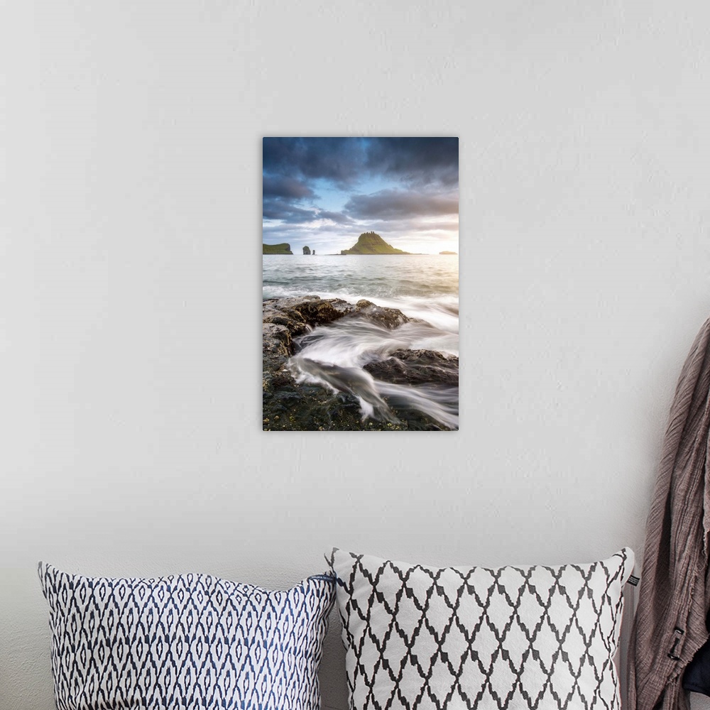 A bohemian room featuring Vagar island, Faroe Islands, Denmark. Coastal rocks with Tinholmur islet at the background at sun...