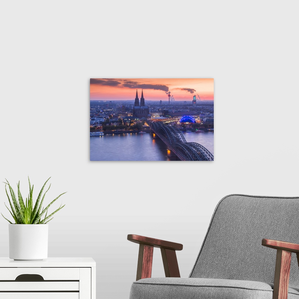 A modern room featuring Cologne Cathedral and Hohenzoller Bridge over River Rhine in Cologne city at dusk. Cologne city (...