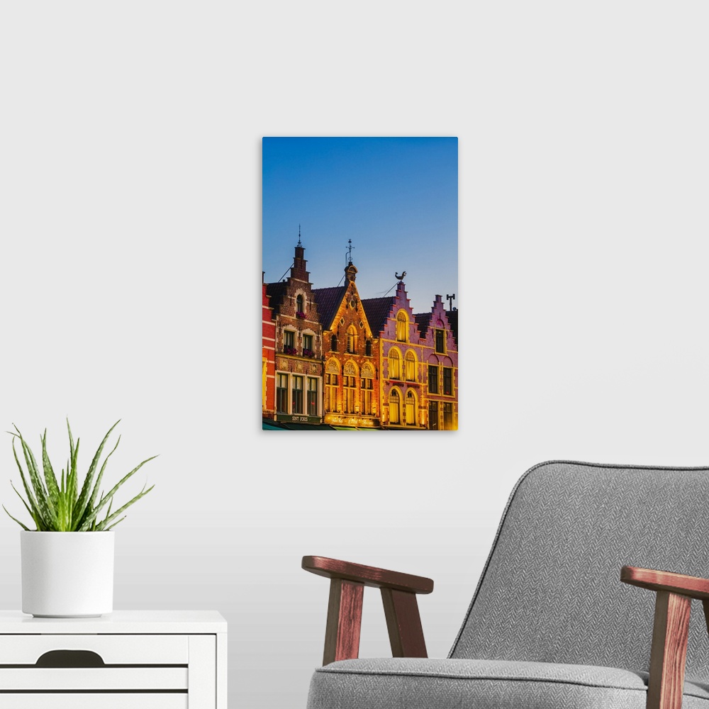 A modern room featuring Detail of the colored houses facades in Markt Square in Bruges by night, Belgium