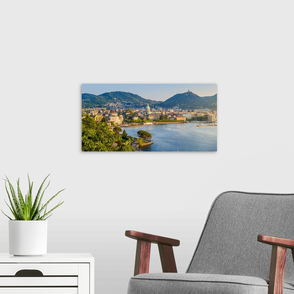 A modern room featuring Como, Lombardy, Italy. High angle view cityscape of Como and the lake front, with the Cathedral o...