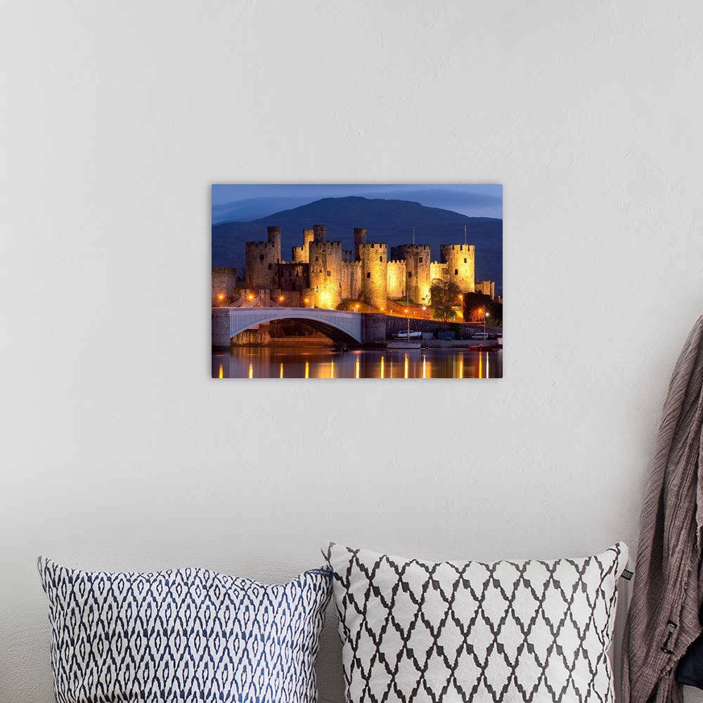 A bohemian room featuring Conwy Castle illuminated at night, Conwy, Wales. Spring (May) 2017.