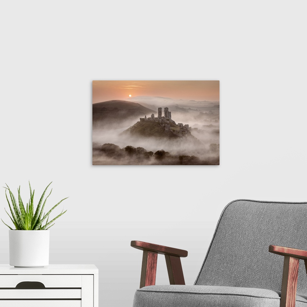 A modern room featuring Corfe Castle at dawn surrounded by mist, Dorset, England