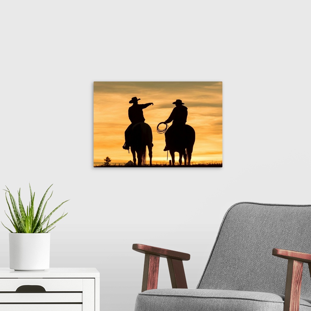 A modern room featuring Cowboys and horses in silhouette at dawn on ranch, British Colombia, Canada.