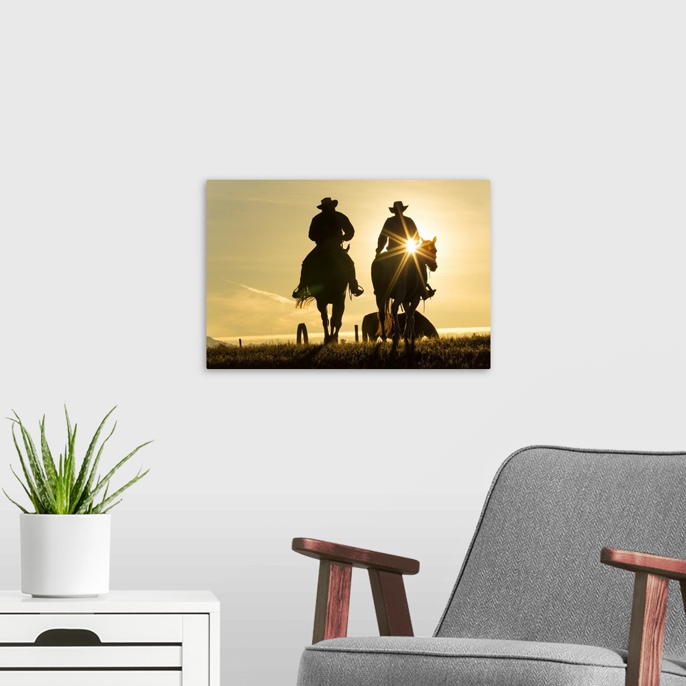A modern room featuring Cowboys on horses, sunrise, British Colombia, Canada.