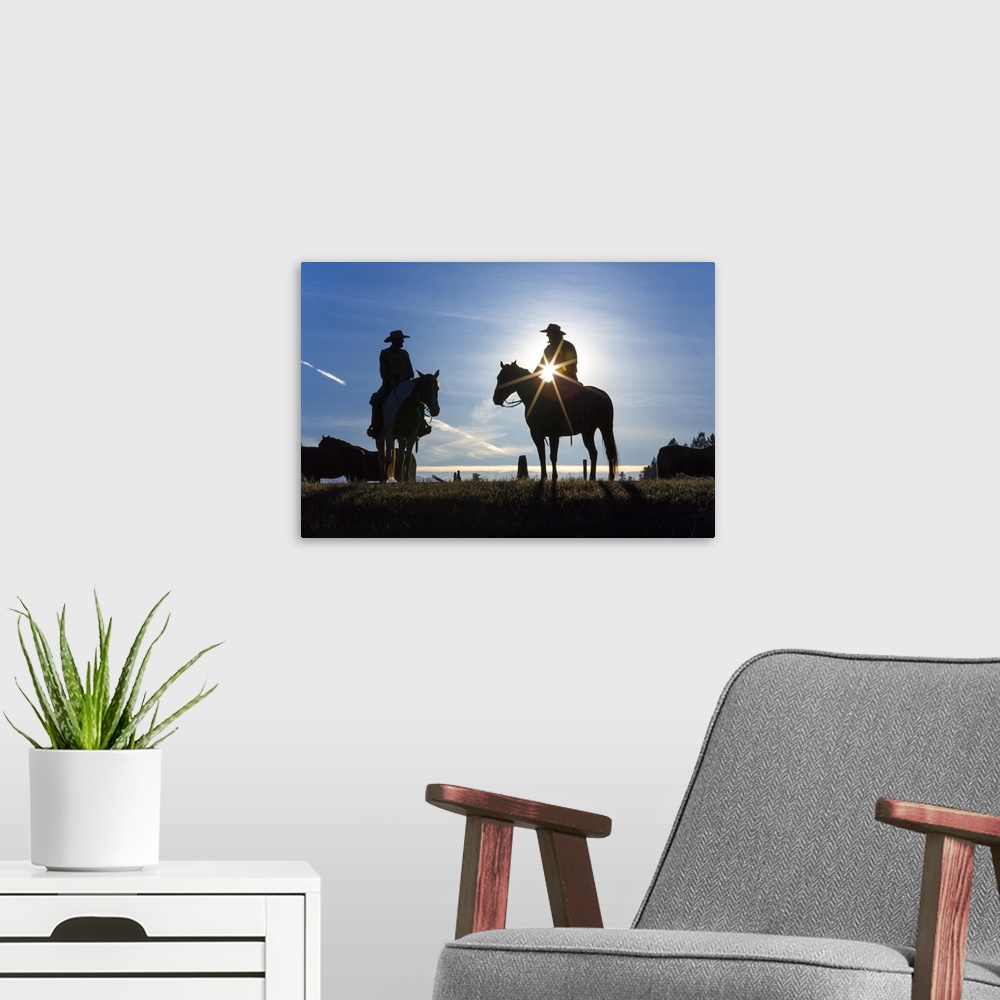 A modern room featuring Cowboys on horses, sunrise, British Colombia, Canada.