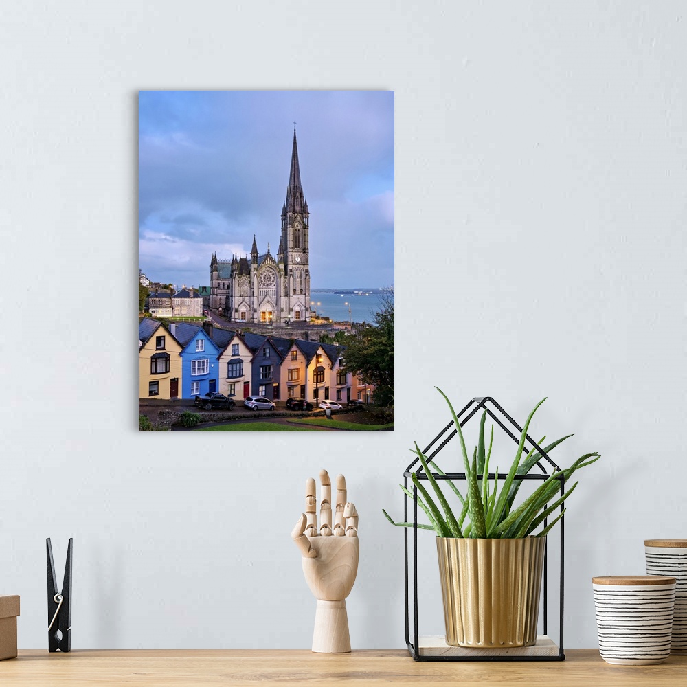 A bohemian room featuring Deck of Cards colourful houses and St. Colman's Cathedral at dusk, elevated view, Cobh, County Co...