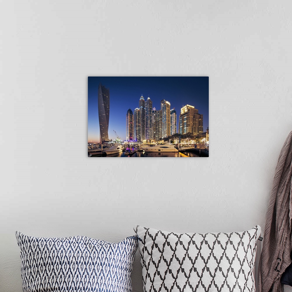 A bohemian room featuring Dubai Marina at twilight with the Cayan Tower (Infinity Tower), the Dubai Marriott Harbour Hotel ...