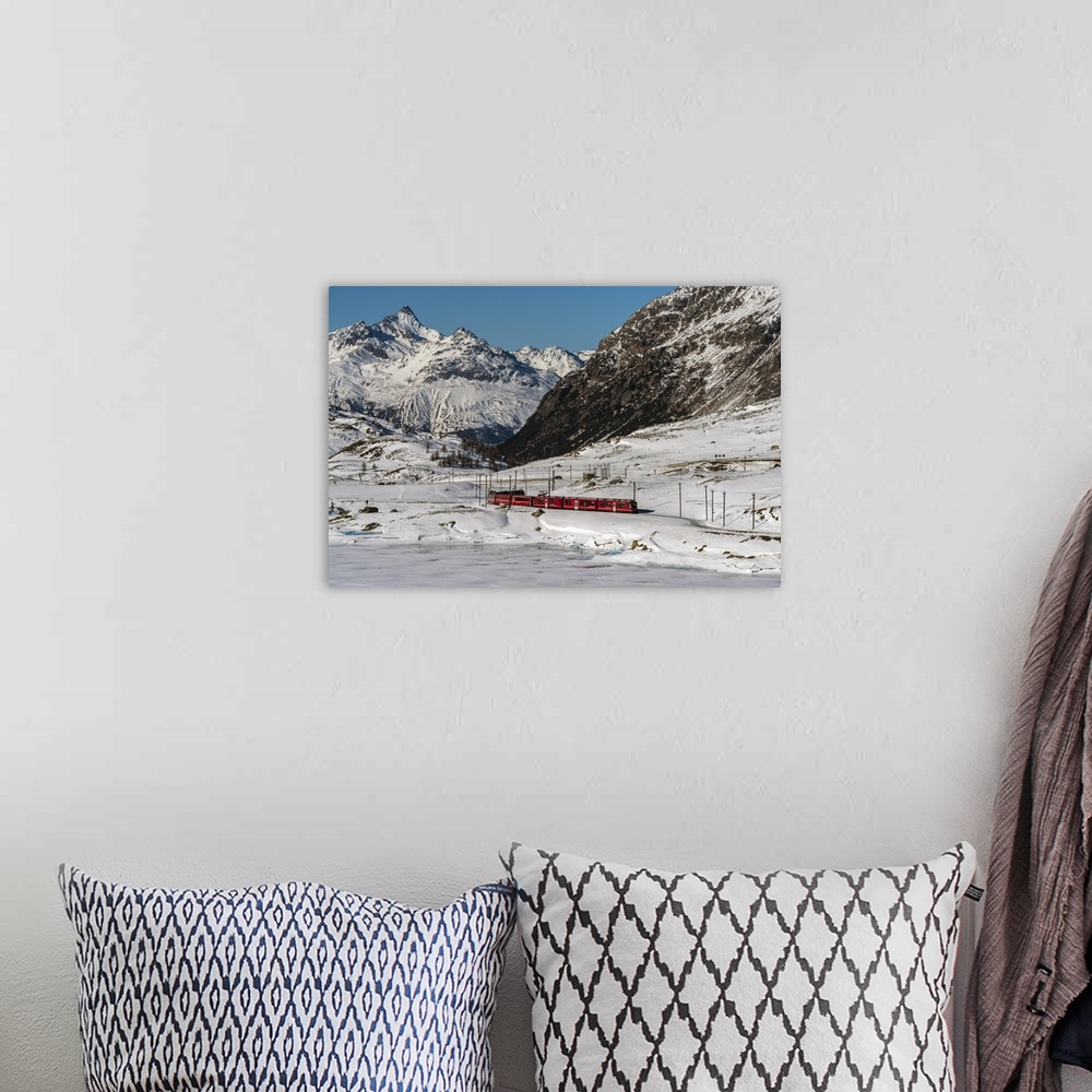 A bohemian room featuring The famous Bernina Express red train passing Lago Bianco in a scenic winter mountain landscape, G...