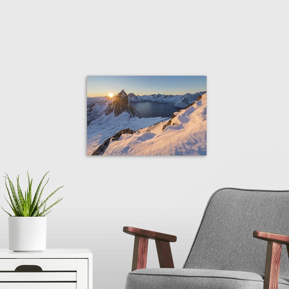 A modern room featuring First lights of sunrise on Mount Segla and Mefjorden framed by the frozen sea seen from peak Hest...