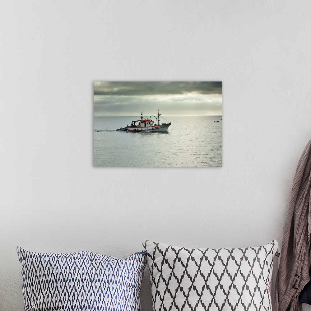 A bohemian room featuring Fishing boat going to the sea. Setubal, Portugal