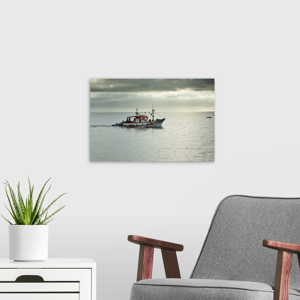 A modern room featuring Fishing boat going to the sea. Setubal, Portugal