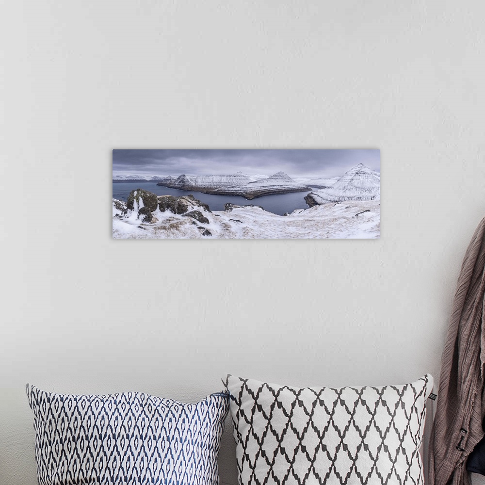 A bohemian room featuring Snow covered mountain scenery above Funningsfjordur on the island of Eysturoy, Faroe Islands, Den...