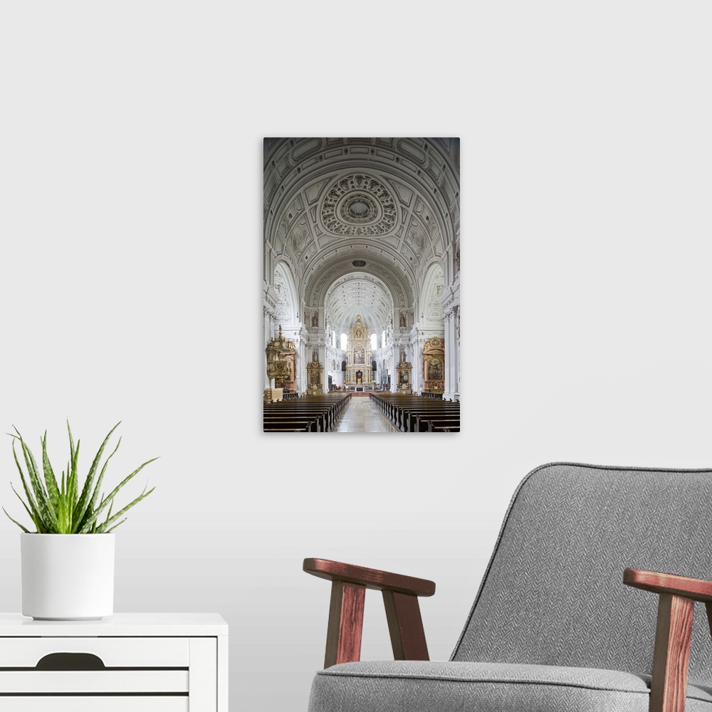 A modern room featuring Germany, Bavaria, Munich. The nave of Michaelskirche has an ornate and impressive barrel vaulted ...