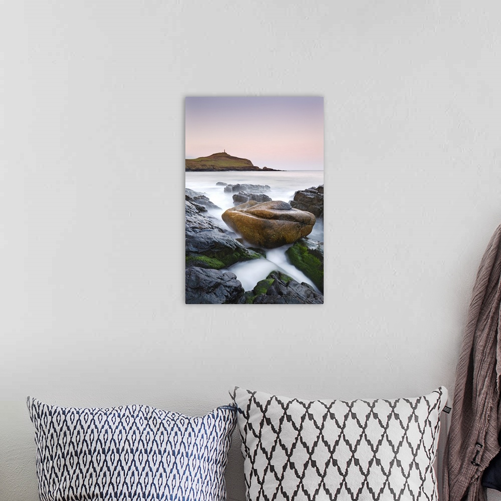 A bohemian room featuring Huge granite boulder lodged on the shores of Porth Ledden at dawn, Cornwall, England. Spring, Apr...