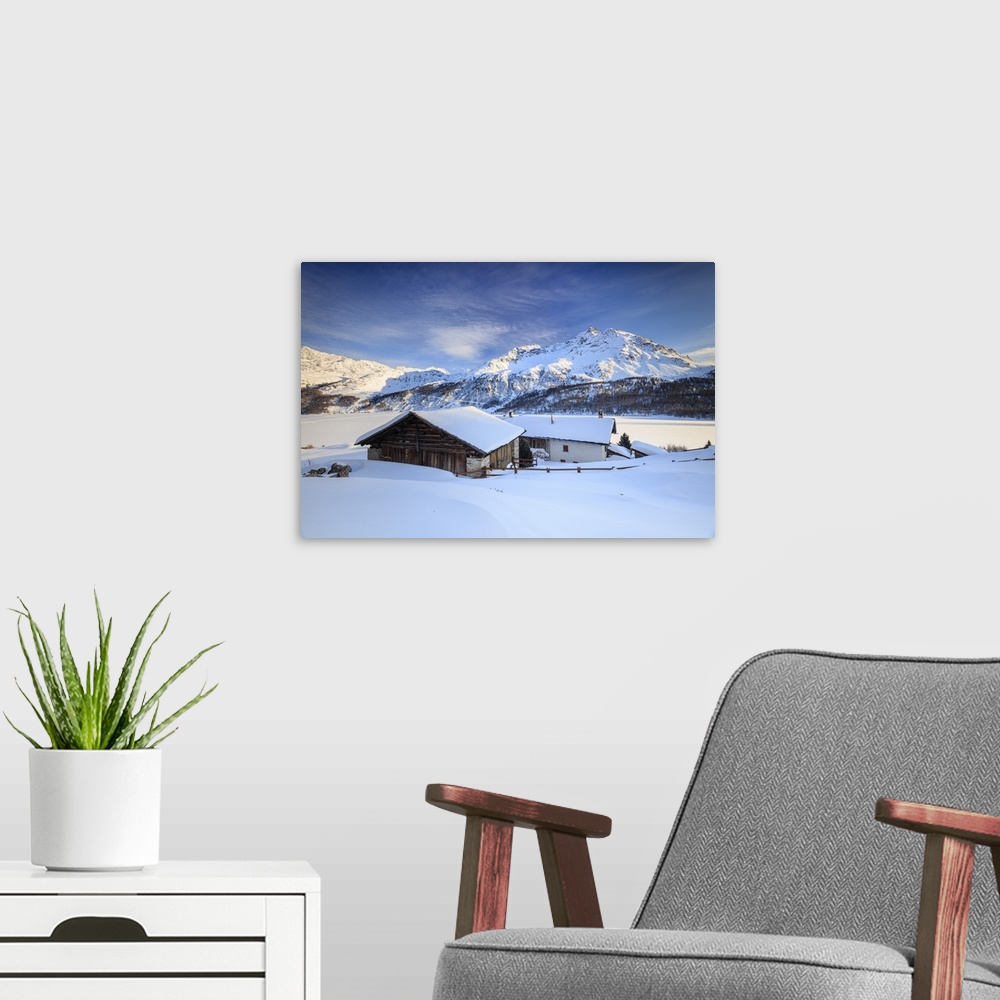 A modern room featuring Huts and mountains covered in snow at sunset Spluga Maloja Canton of Graubunden Engadin Switzerland.