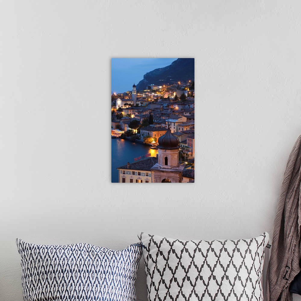 A bohemian room featuring Italy, Lombardy, Lake District, Lake Garda, Limone sul Garda, aerial town view, dusk