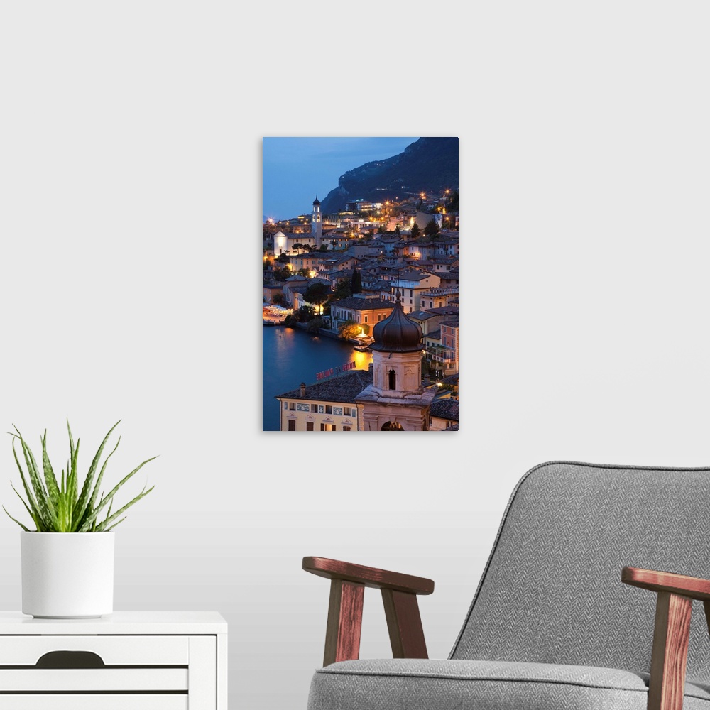 A modern room featuring Italy, Lombardy, Lake District, Lake Garda, Limone sul Garda, aerial town view, dusk