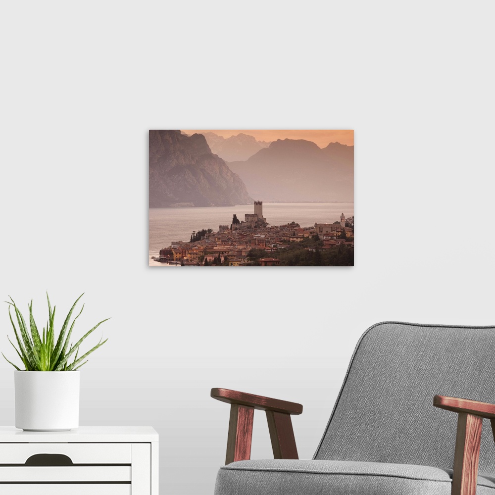 A modern room featuring Italy, Veneto, Lake District, Lake Garda, Malcesine, aerial town view, dawn