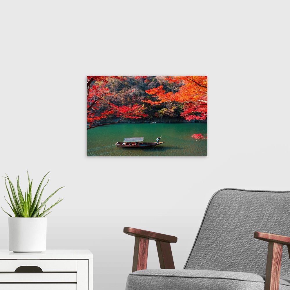A modern room featuring Kyoto, Kyoto prefecture, Kansai region, Japan. Tour boats along the Katsura river in autumn.