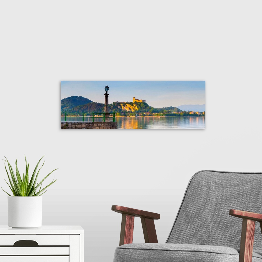 A modern room featuring The imposing La Rocca fortress viewd from Arona at sunset, Lake Maggiore, Piedmont, Italy.