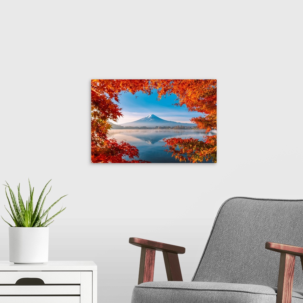 A modern room featuring Lake Kawaguchi and Mt Fuji framed by red maple leaves in autumn, Yamanashi Prefecture, Japan.