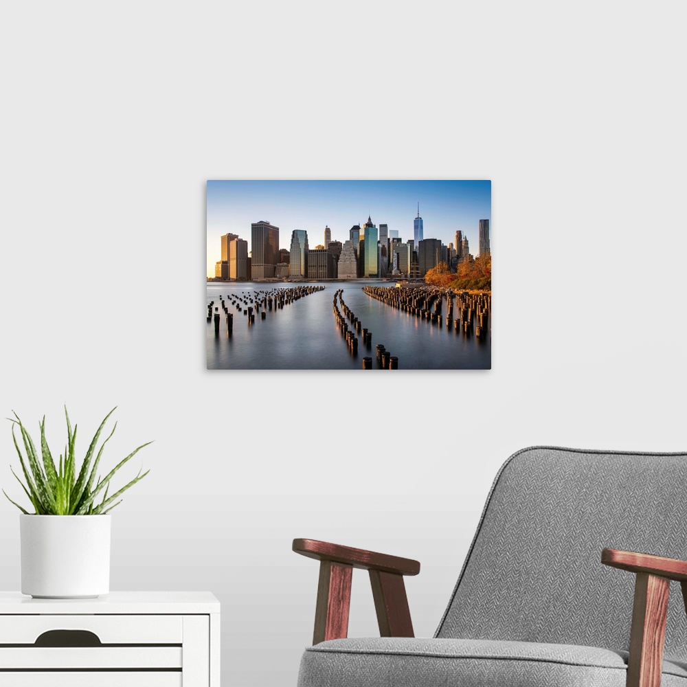 A modern room featuring Lower Manhattan skyline at sunset from Brooklyn Bridge Park, Brooklyn, New York, USA.