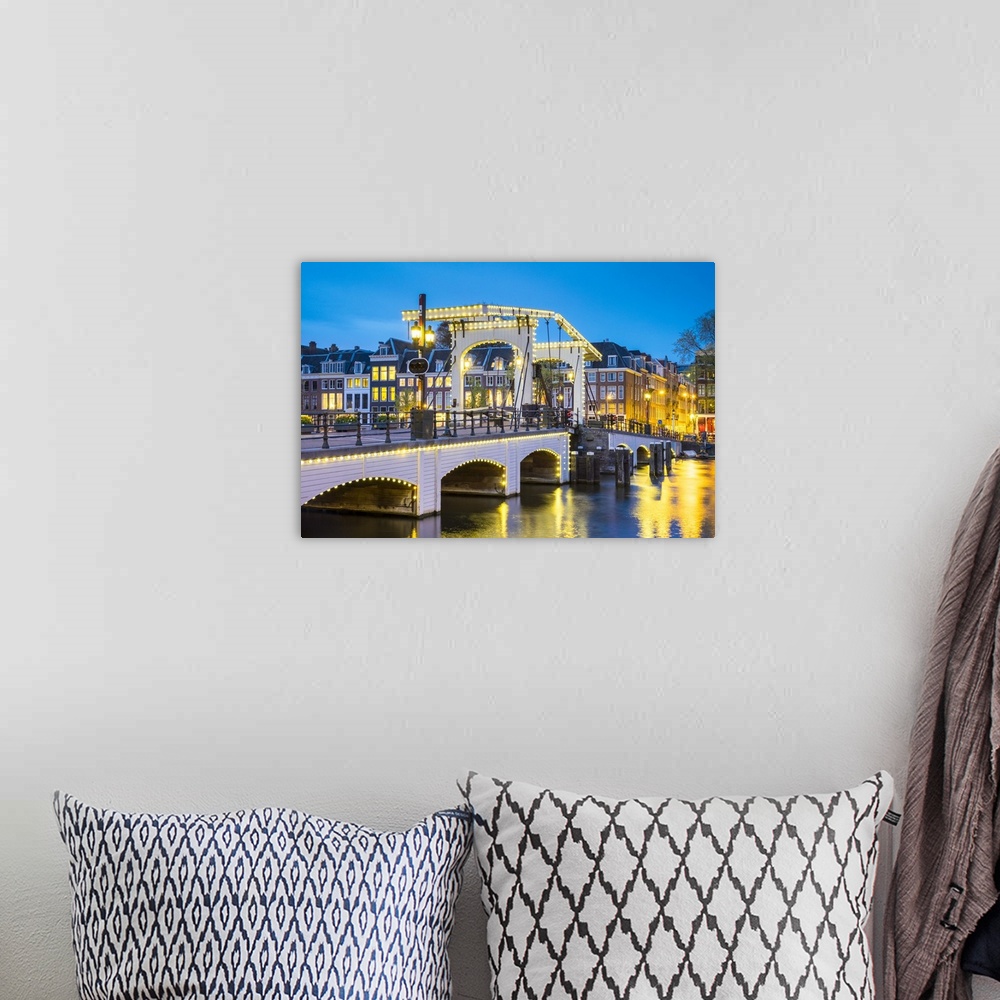 A bohemian room featuring Netherlands, North Holland, Amsterdam. Magere Brug, Skinny Bridge, on the Amstel River at night.