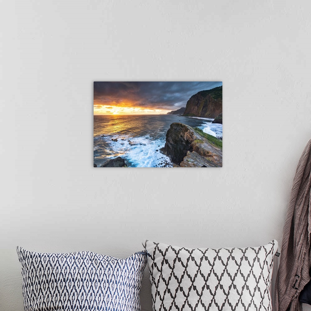A bohemian room featuring Man on cliffs looking at waves at dawn, Miradouro Do Guindaste viewpoint, Madeira island, Portugal.