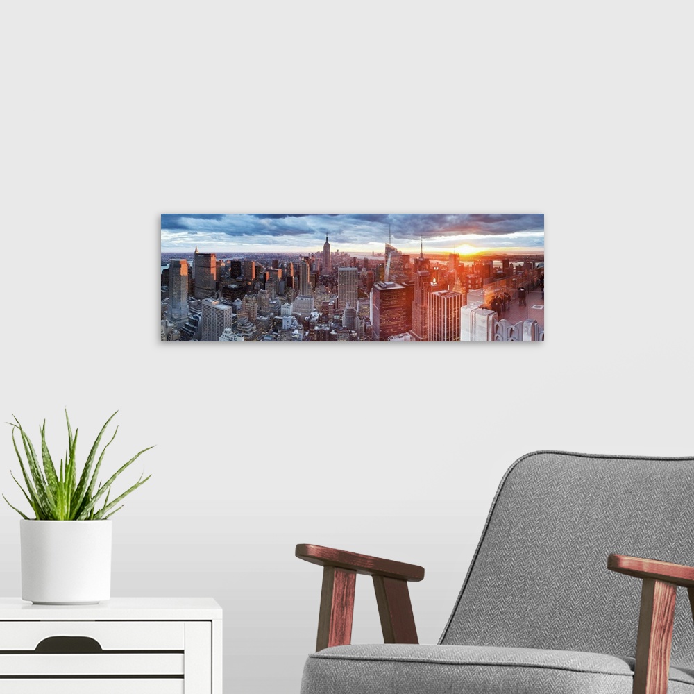 A modern room featuring Manhattan view towards Empire State Building at sunset from Top of the Rock, at Rockefeller Plaza...