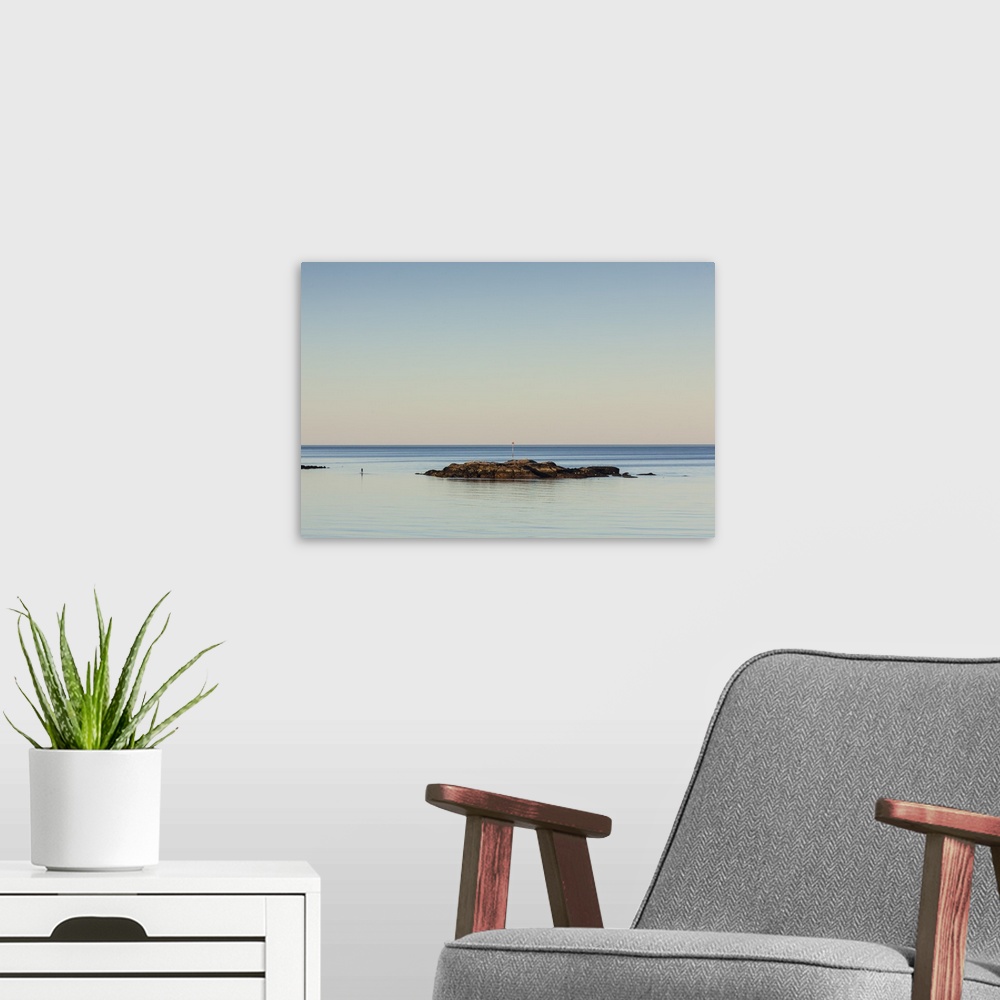 A modern room featuring USA, Massachusetts, Cape Ann, Rockport, paddleboarder in Rockport Harbor, dusk.