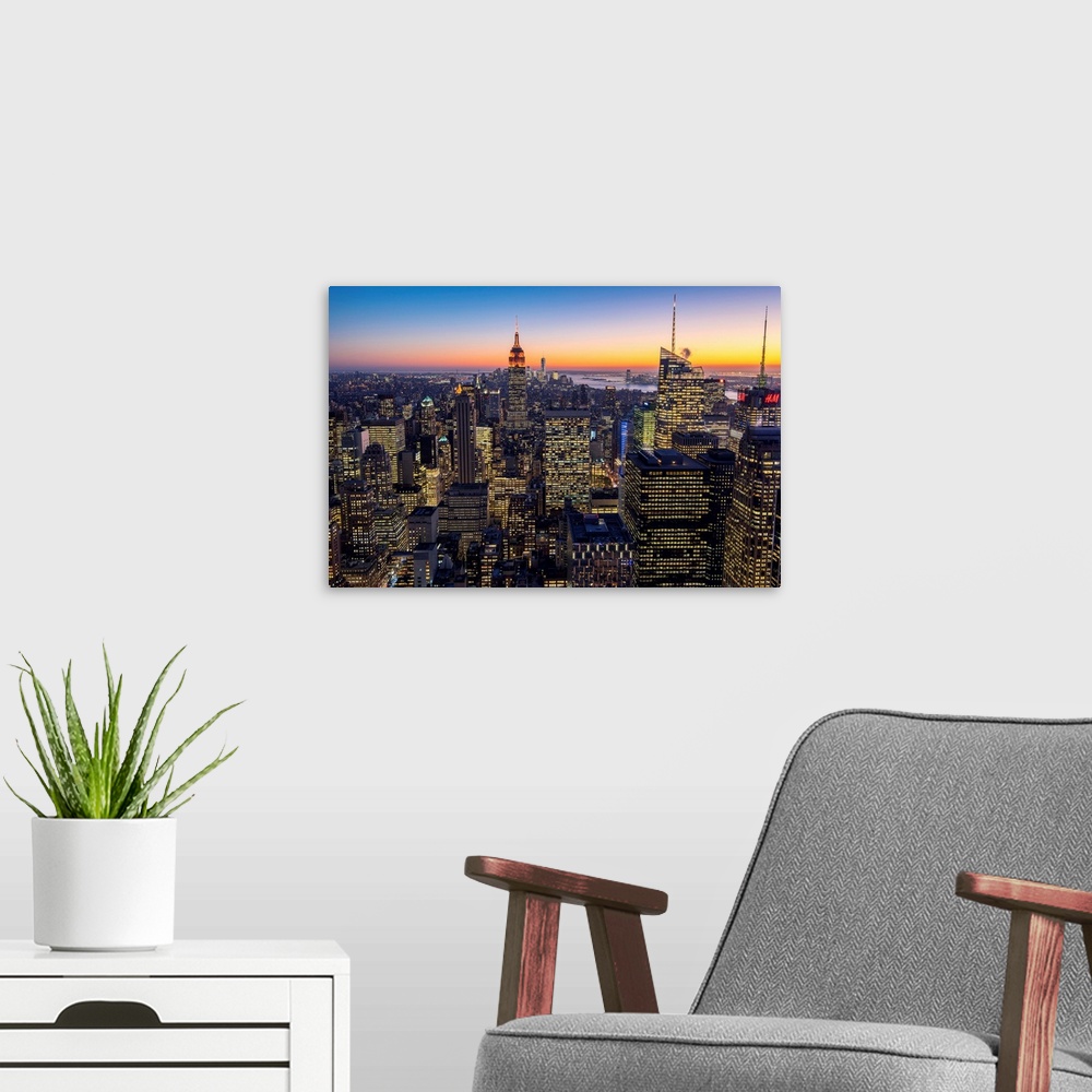 A modern room featuring Midtown Manhattan skyline at dusk, New York, USA.