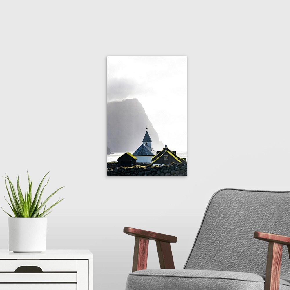 A modern room featuring Misty sky over the traditional church of Vidareidi ovelooking a fjord, Vidoy Island, Faroe Islands