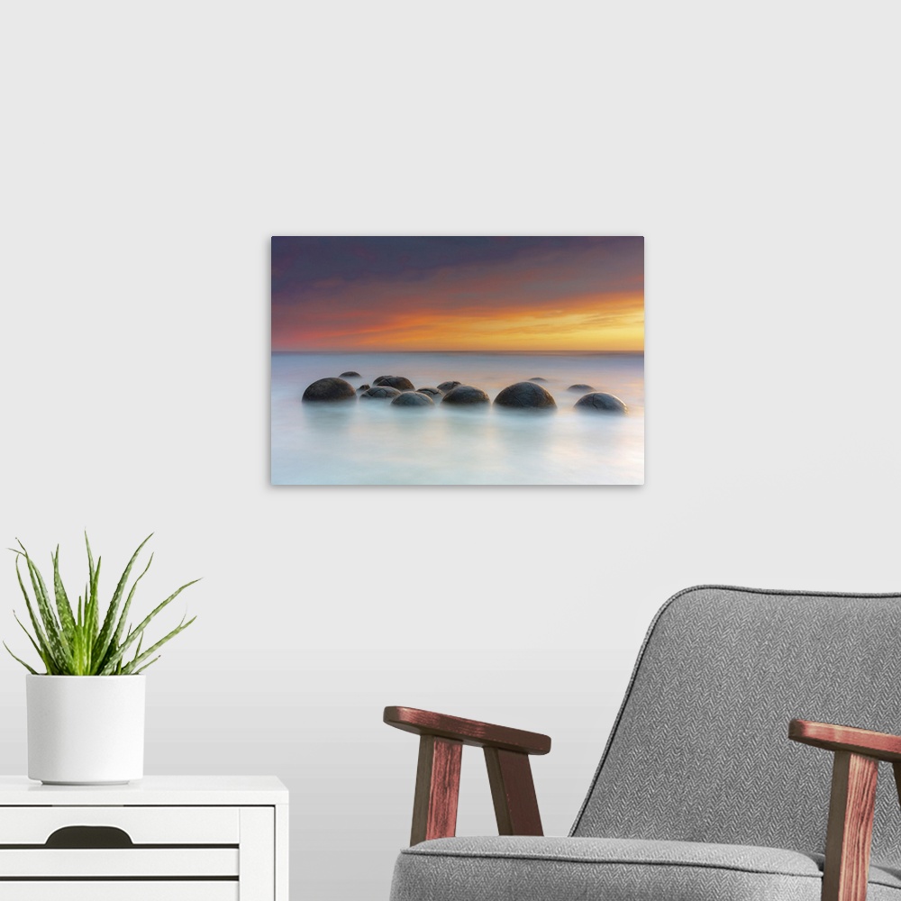 A modern room featuring Moeraki Boulders rock formations by the sea at sunrise, Otago, New Zealand