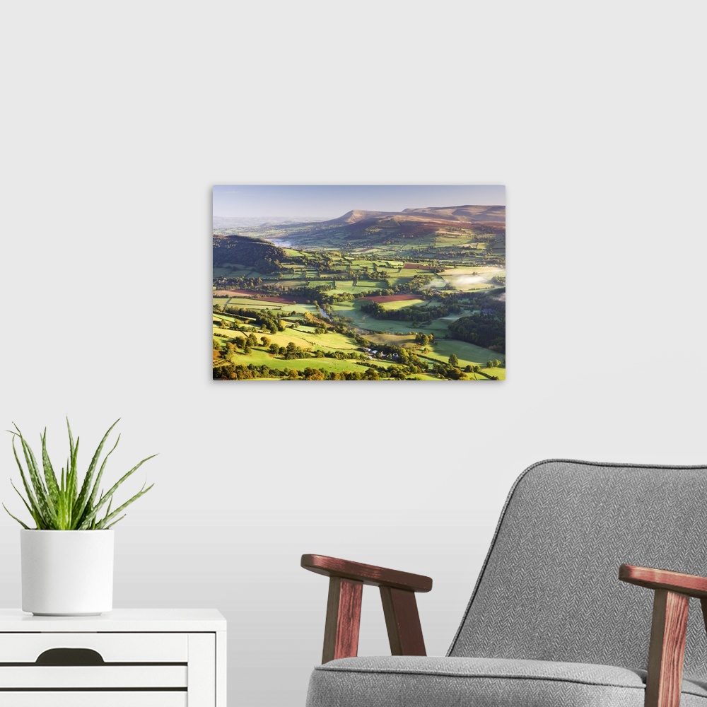 A modern room featuring Morning sunshines illuminates the patchwork fields in the Usk Valley, looking towards the Black M...