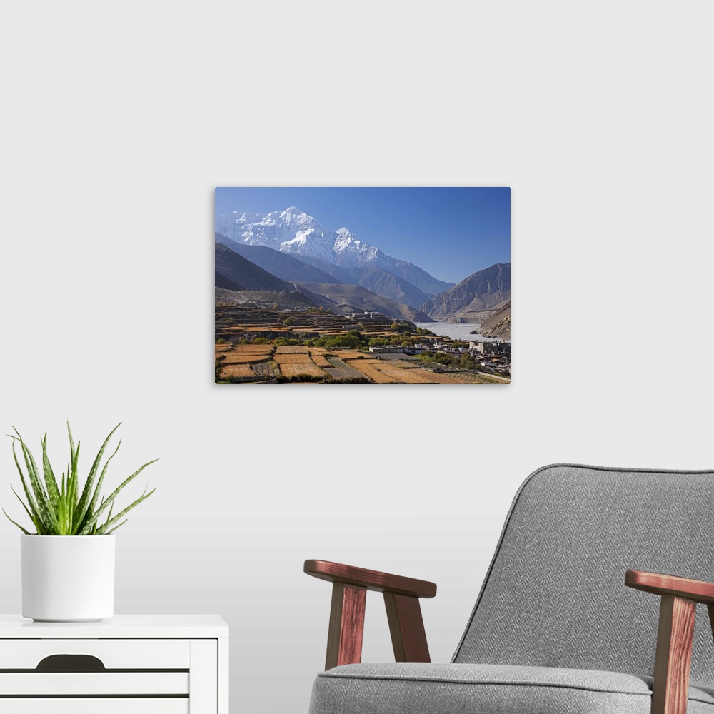 A modern room featuring Nepal, Mustang, Kagbeni. The soaring peak of Nilgiri behind the village of Kagbeni.