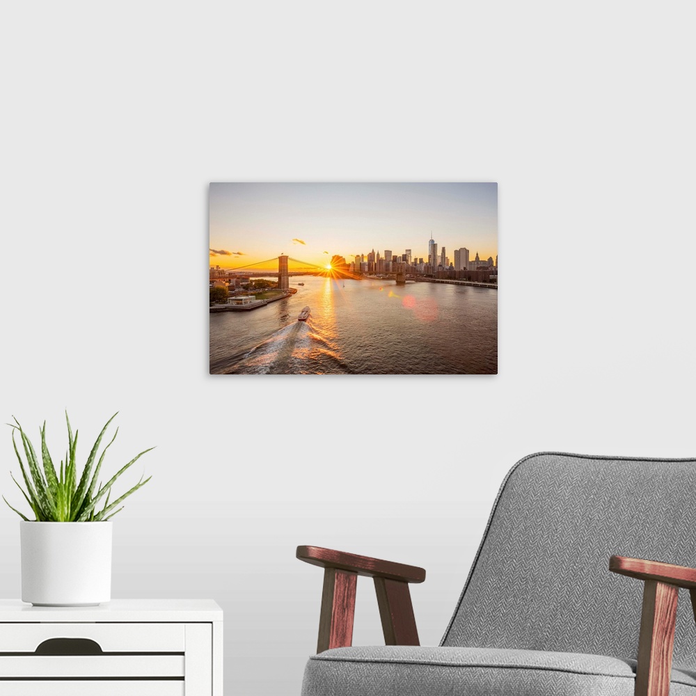 A modern room featuring USA, New York, Lower Manhattan Skyline and Brooklyn Bridge over East River at Sunset.