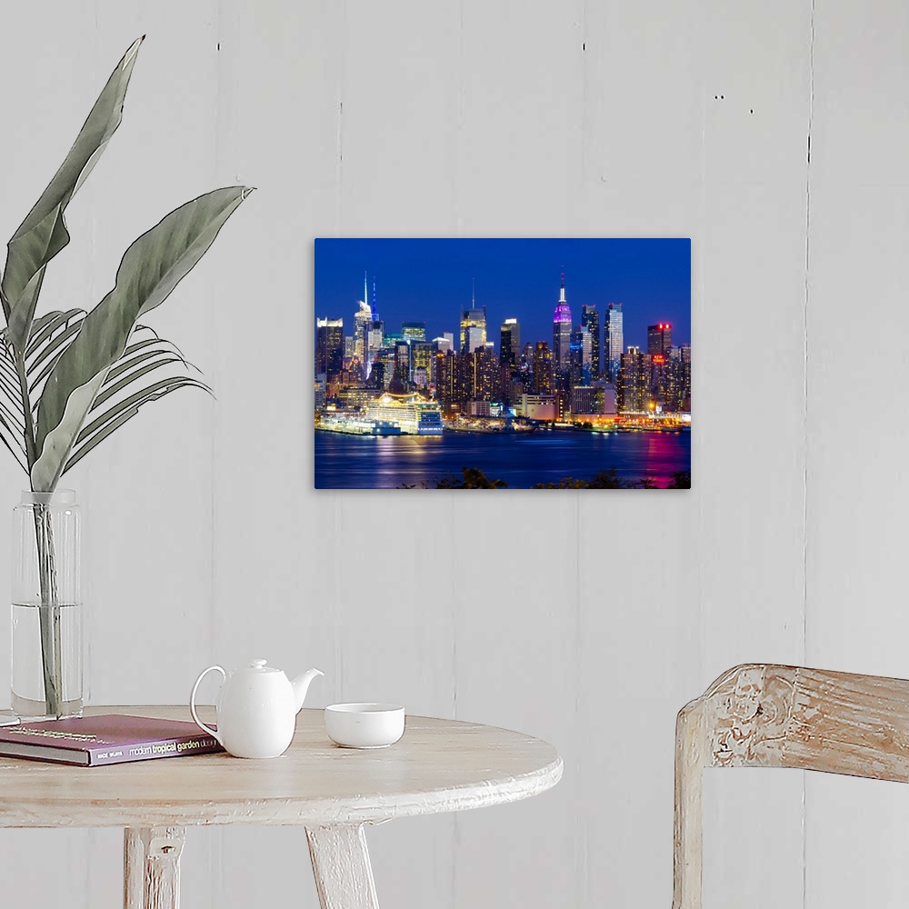 A farmhouse room featuring Canvas print of the NYC cityscape lit up in colored lights along a waterfront.