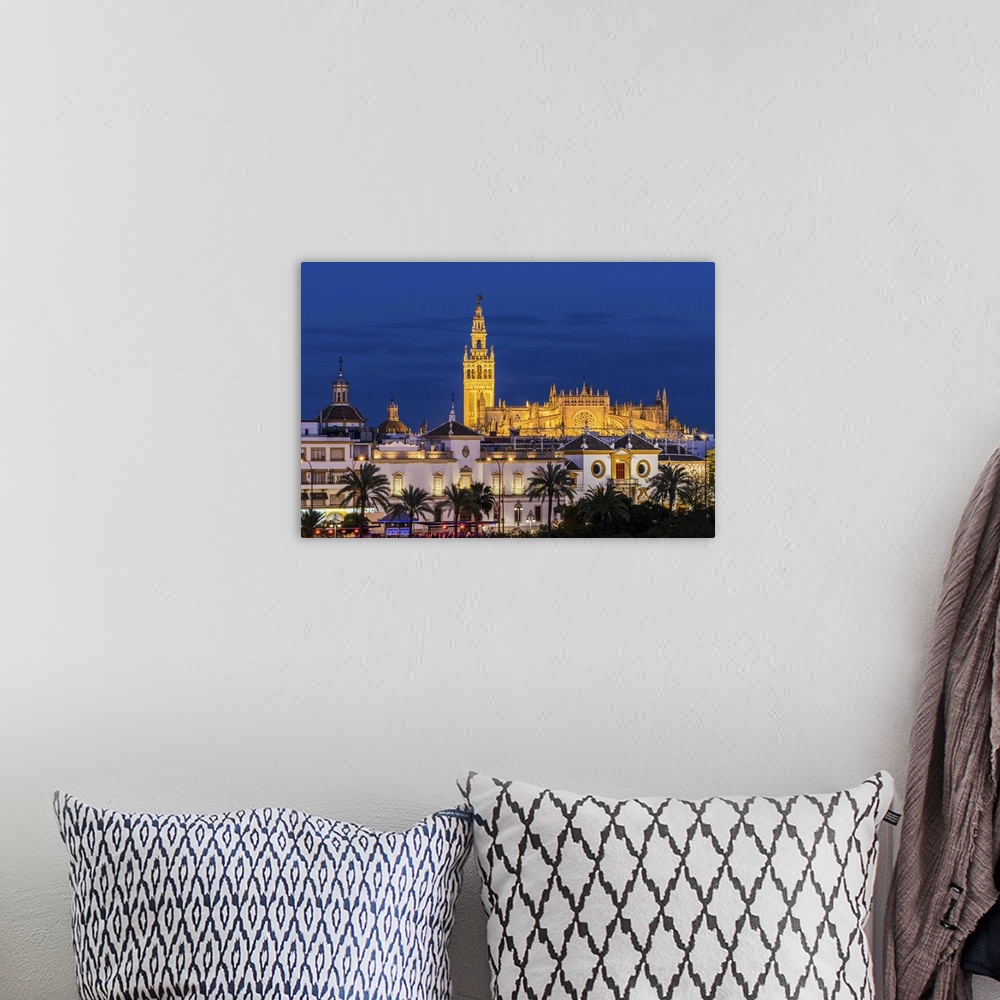 A bohemian room featuring Night view of city skyline with Cathedral and Giralda bell tower, Seville, Andalusia, Spain.