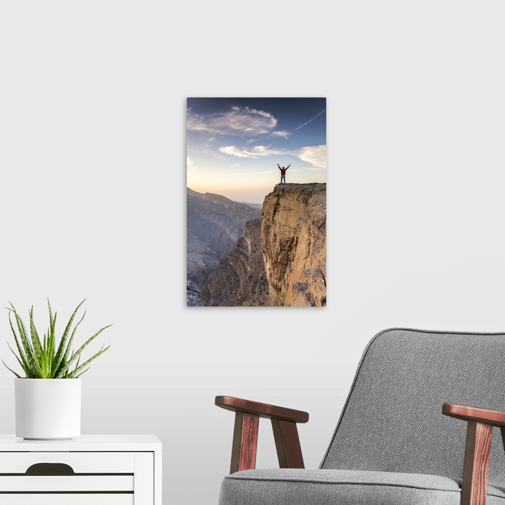 A modern room featuring Oman, Wadi Ghul, Jebel Shams. The Grand canyon of Oman, tourist on the edge looking at view, at s...