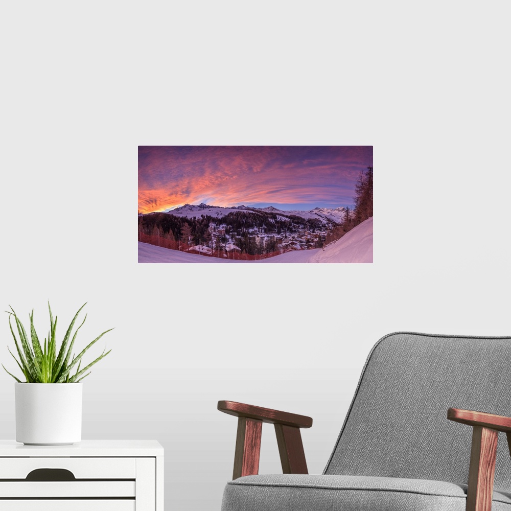 A modern room featuring Panorama of the alpine village of Madesimo and snowy ski slopes at sunset Spluga Valley Valtellin...
