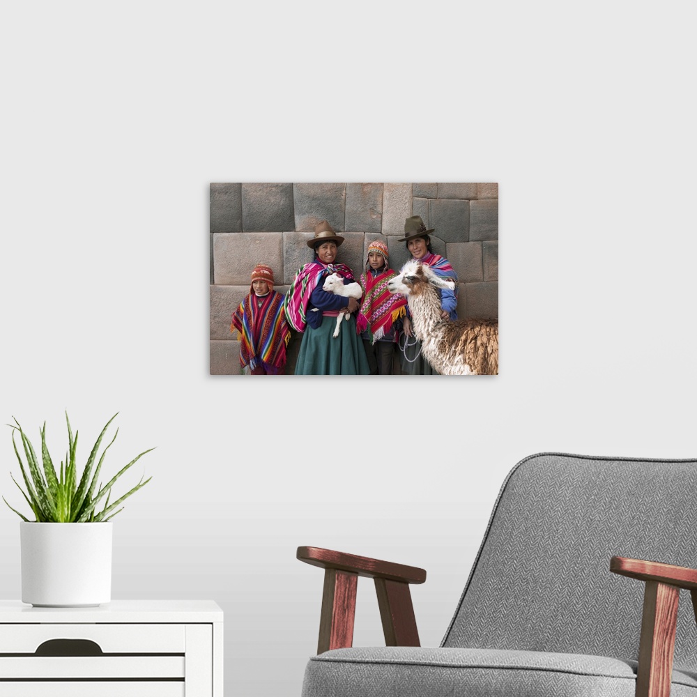 A modern room featuring South America, Peru, Cusco. Quechua people standing in front of an Inca wall, holding a lamb and ...