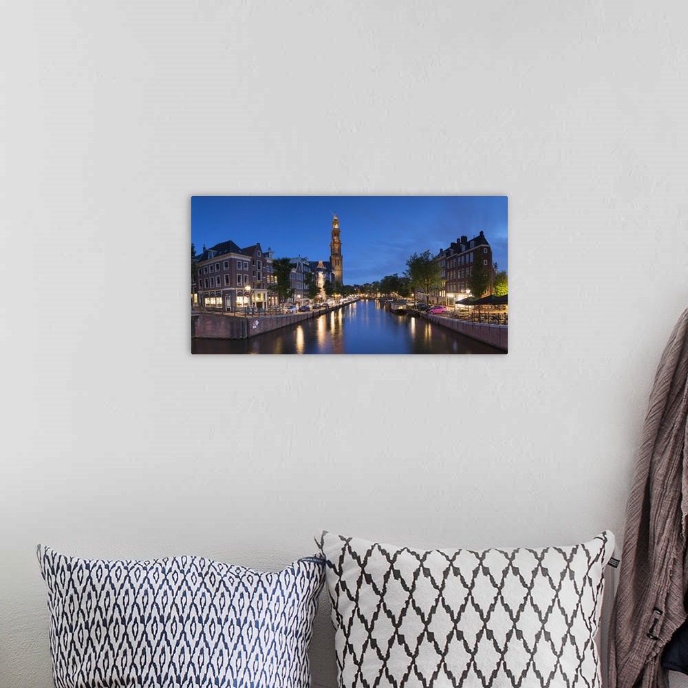 A bohemian room featuring Prinsengracht canal and Westerkerk at dusk, Amsterdam, Netherlands.