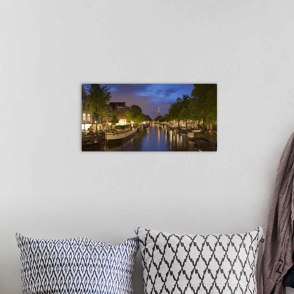 A bohemian room featuring Prinsengracht canal and Westerkerk at dusk, Amsterdam, Netherlands.